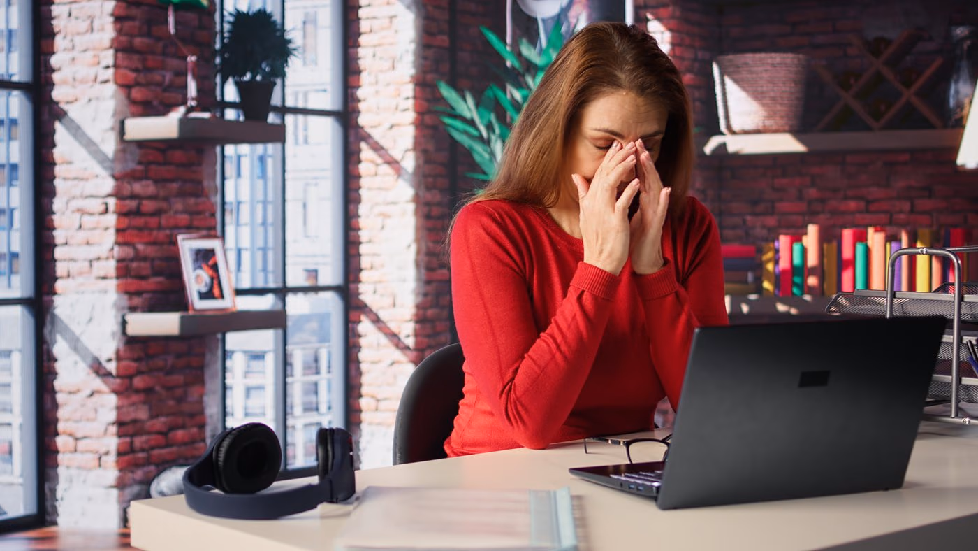 Une webdesigneuse fatiguée se frotte les yeux devant son écran