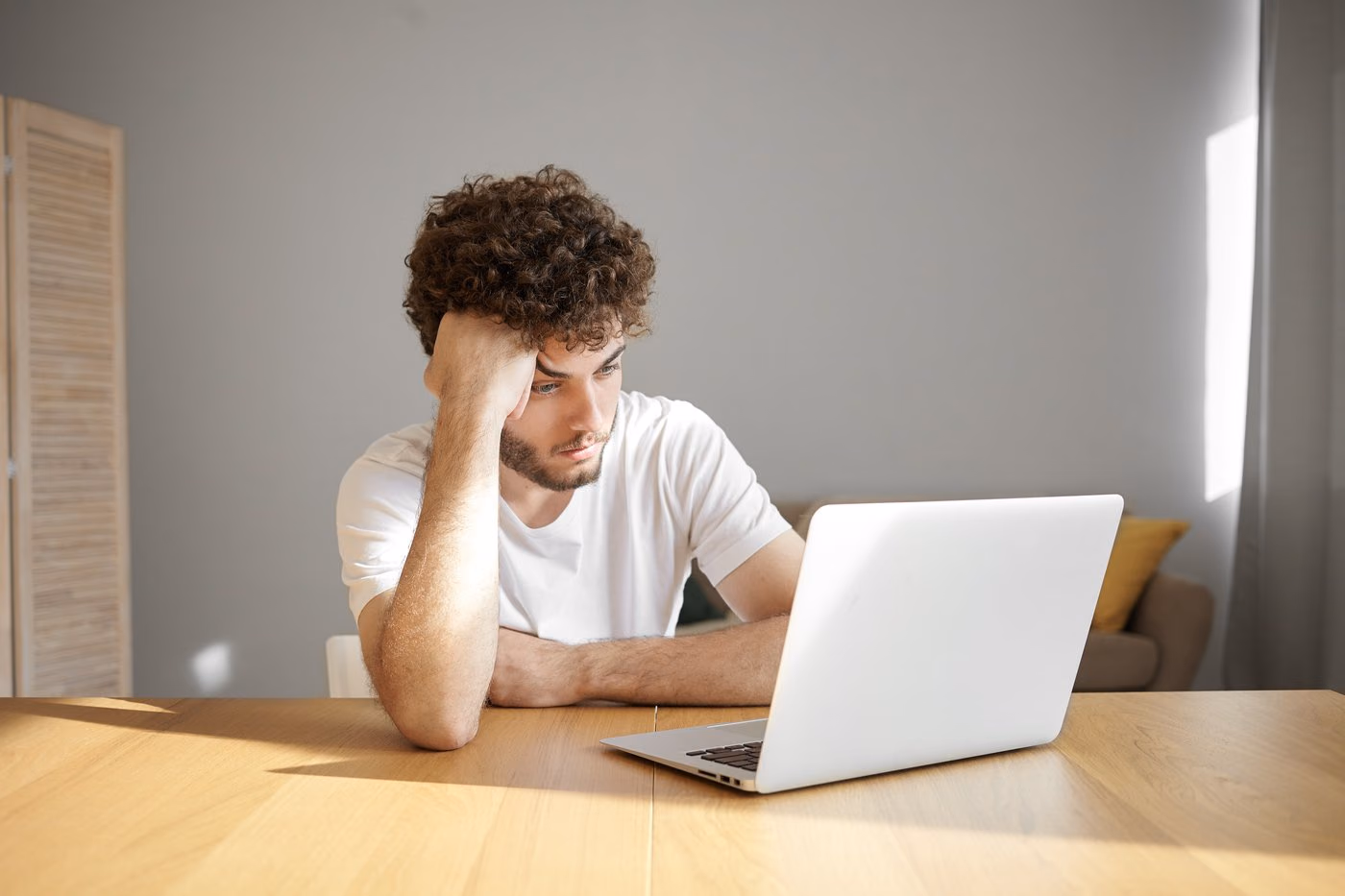 Un jeune freelance découragé devant son ordinateur portable
