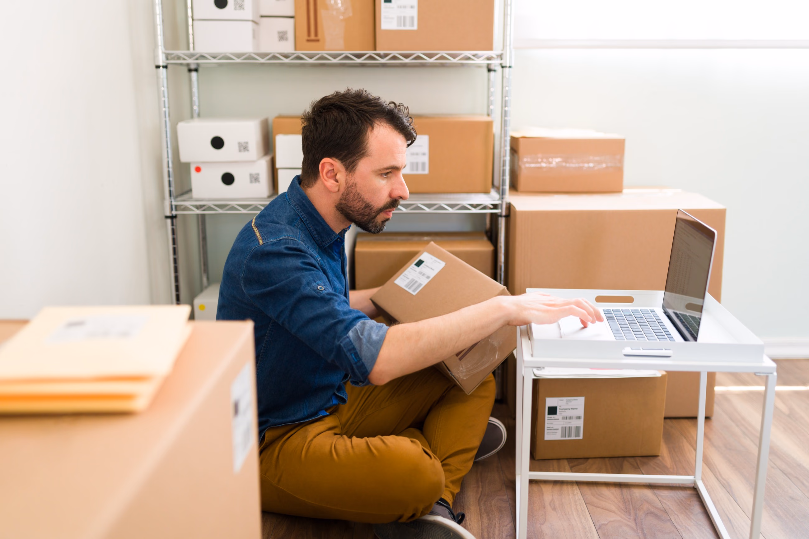 Une e-commerçante prépare ses commandes devant son ordinateur