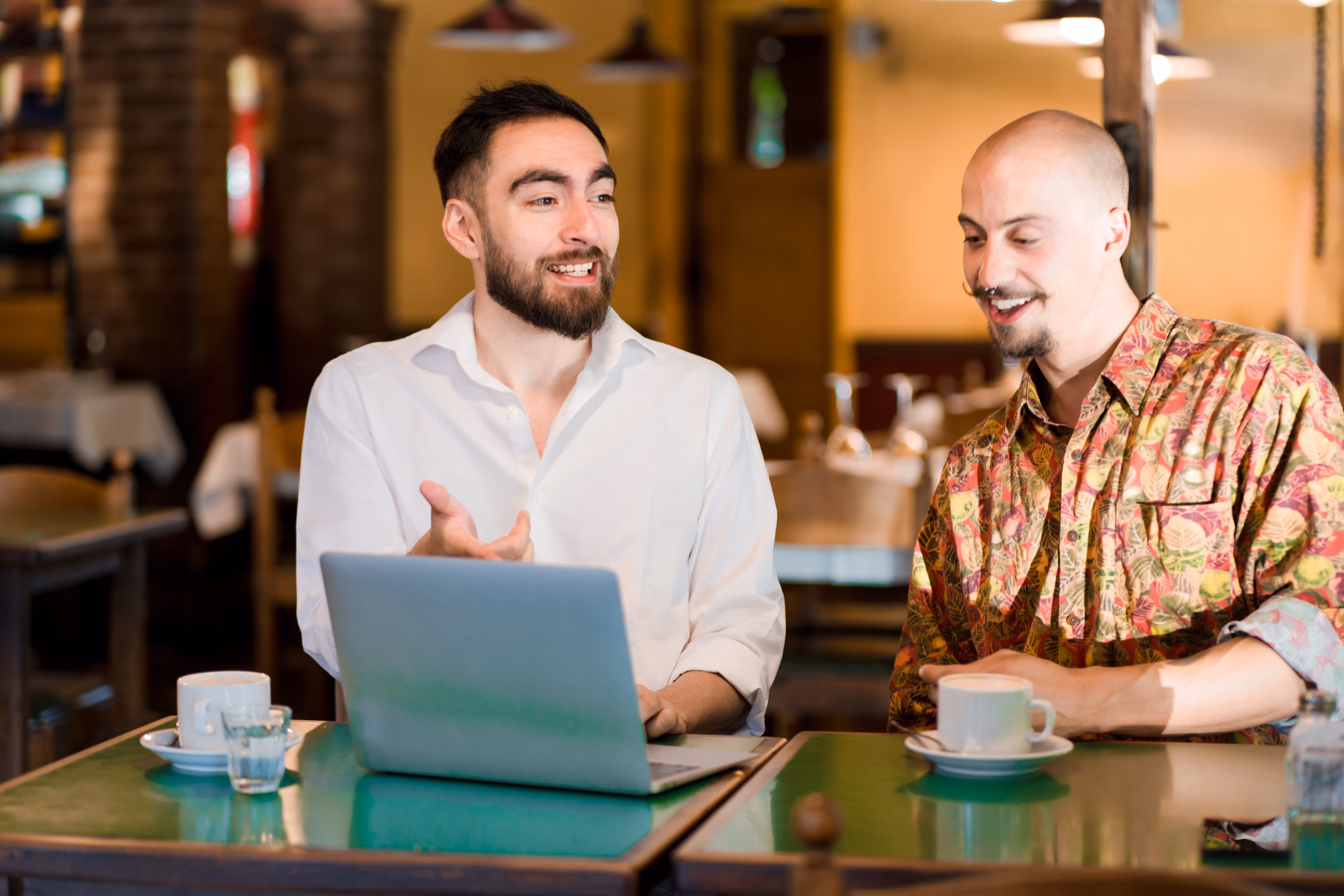 Un freelance présente son travail à son client, autour d’un laptop