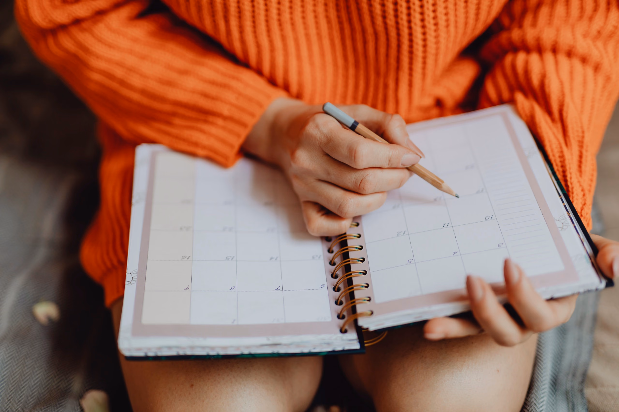 Des mains organisent la semaine sur un agenda papier