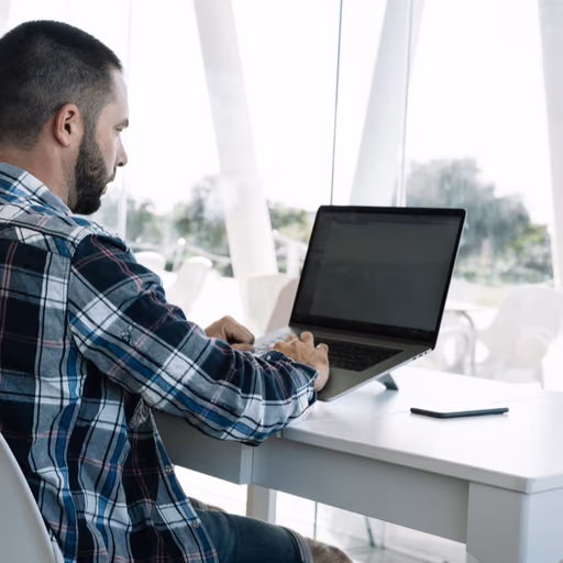 Une personne installée à son bureau, en train de suivre une leçon sur son ordinateur portable